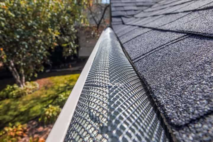 A contractor demonstrating the effectiveness of a gutter guard to a potential client in St. Paul